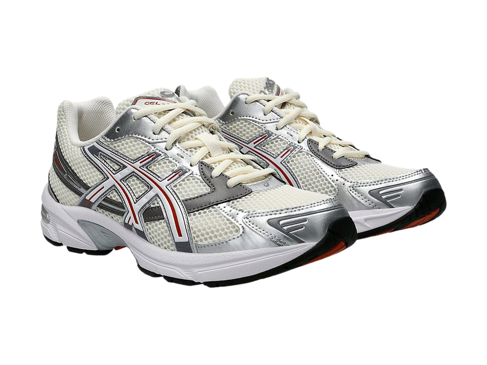 Tenis ASICS GEL-1130 en color crema y blanco con detalles en gris y rojo, vista lateral.