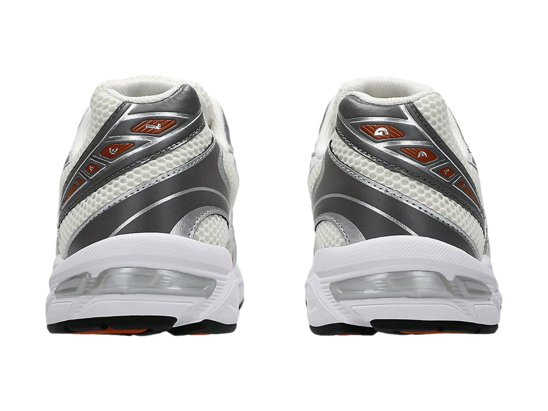 Tenis ASICS GEL-1130 en color crema y blanco con detalles en gris y rojo, vista lateral.