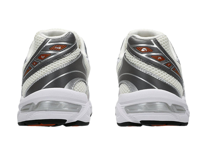 Tenis ASICS GEL-1130 en color crema y blanco con detalles en gris y rojo, vista lateral.