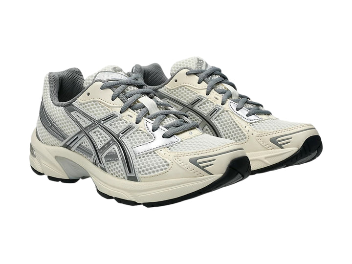 Tenis ASICS GEL-1130 color crema y gris con malla transpirable y suela blanca y negra.