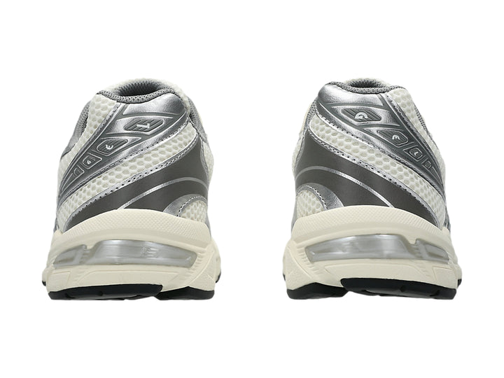 Tenis ASICS GEL-1130 color crema y gris con malla transpirable y suela blanca y negra.