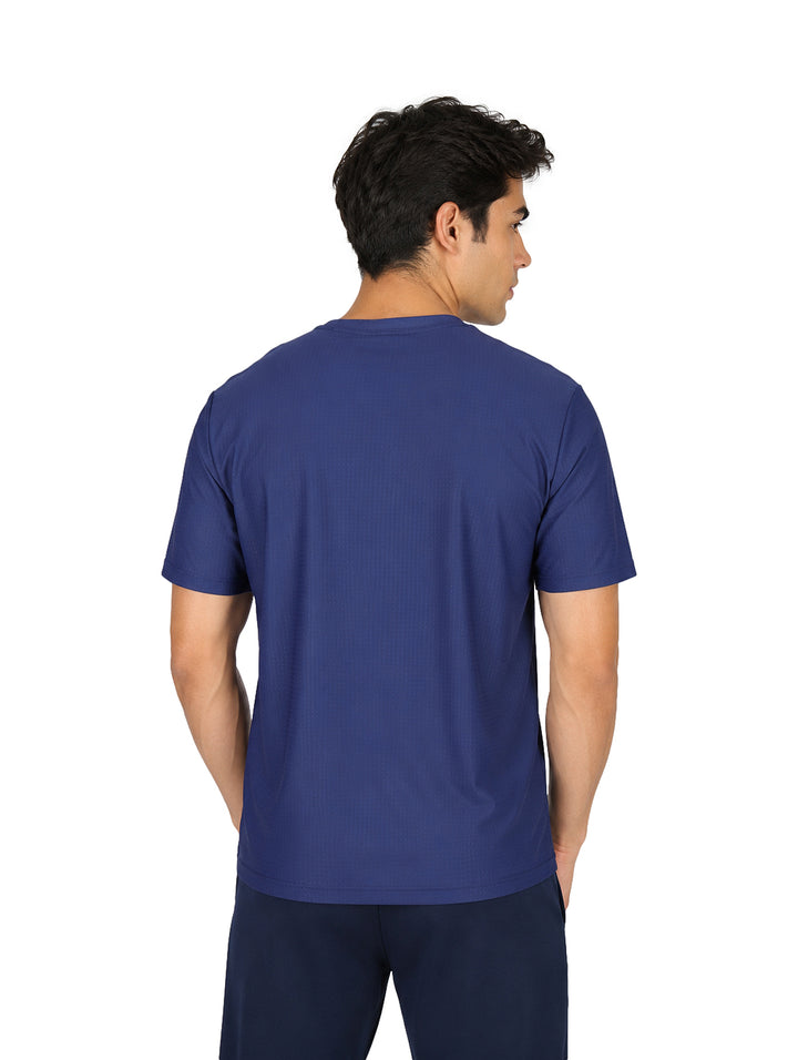 Hombre vistiendo una playera azul marino de manga corta y cuello redondo con tecnolog�a dry fit.