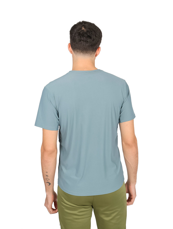 Hombre vistiendo playera de manga corta color verde gris�ceo con cuello redondo y tejido dry fit.