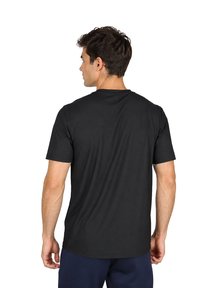 Hombre vistiendo una playera negra de manga corta y cuello redondo con tecnolog�a dry fit.
