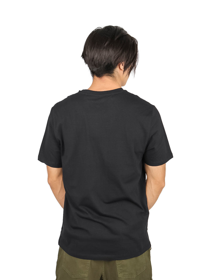 Hombre vistiendo playera negra de manga corta con estampado gráfico amarillo y blanco en el pecho.