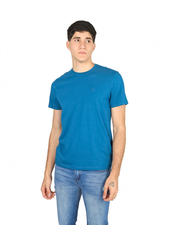 Hombre vistiendo una camiseta de manga corta color azul smoke blue de la marca DKNY.