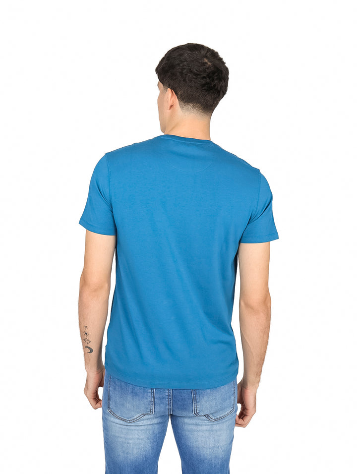 Hombre vistiendo una camiseta de manga corta color azul smoke blue de la marca DKNY.