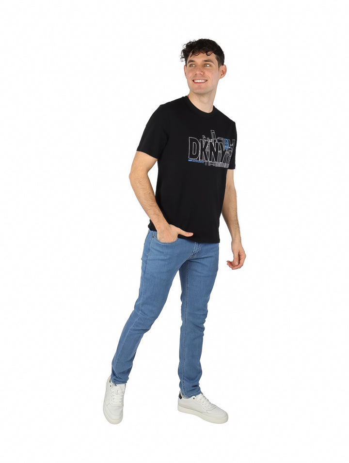 Hombre vistiendo una camiseta negra de manga corta con estampado gráfico de DKNY en el pecho.