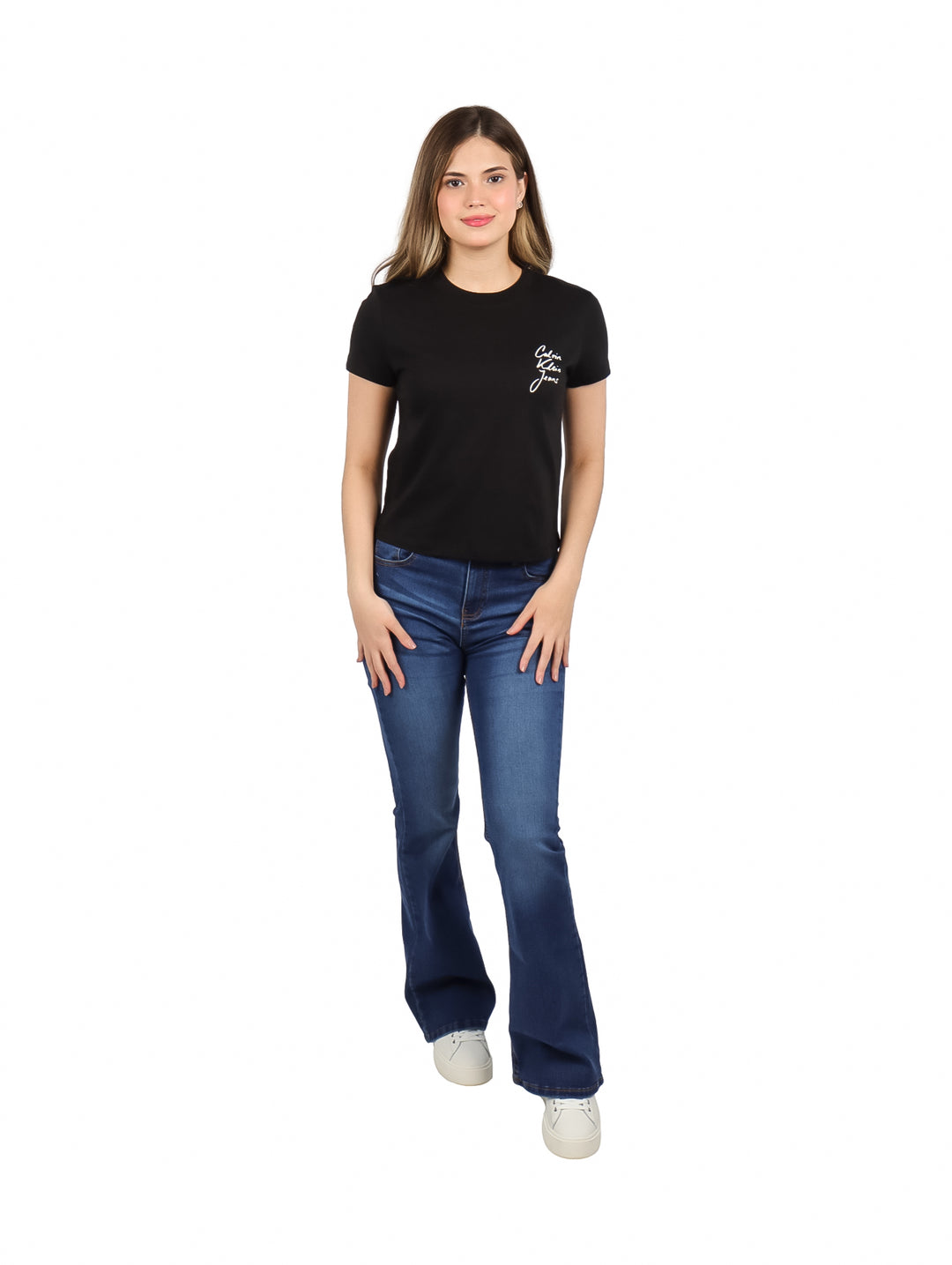Mujer vistiendo blusa negra de manga corta con logotipo de Calvin Klein y jeans azules.