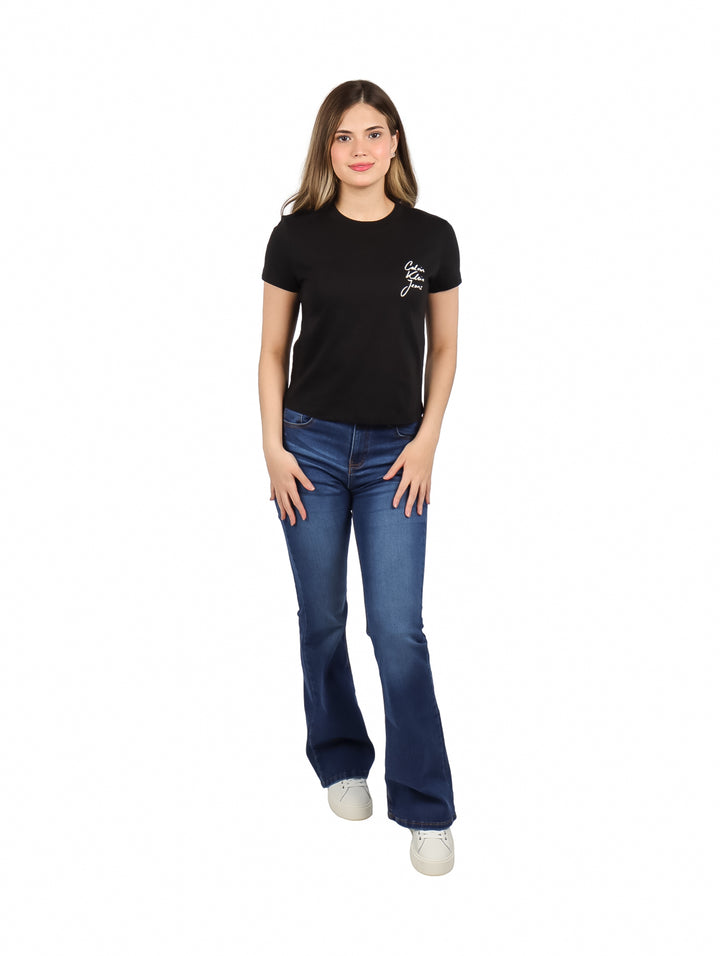 Mujer vistiendo blusa negra de manga corta con logotipo de Calvin Klein y jeans azules.