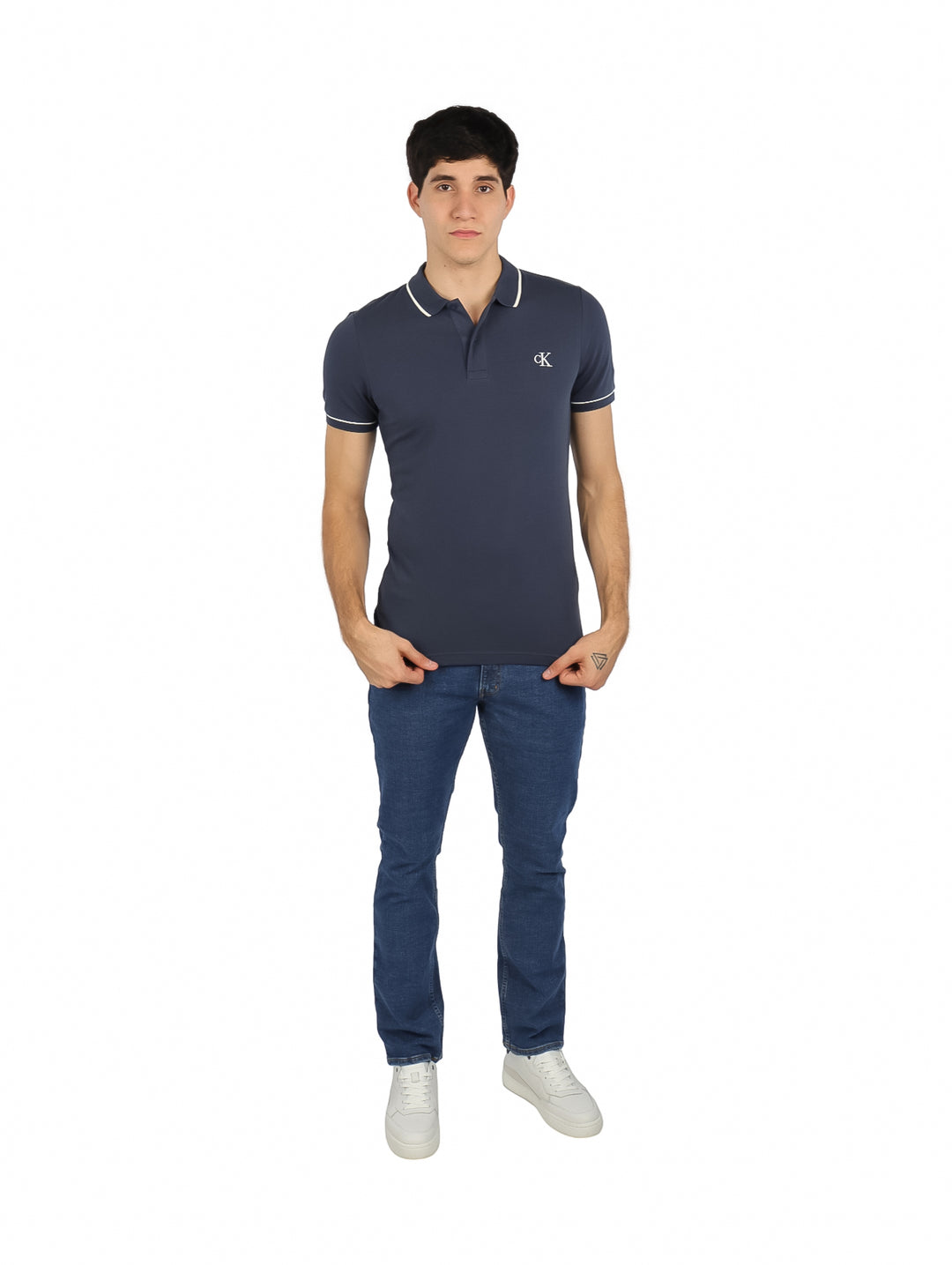 Hombre vistiendo una camiseta polo azul marino de Calvin Klein con detalles blancos en el cuello y mangas.