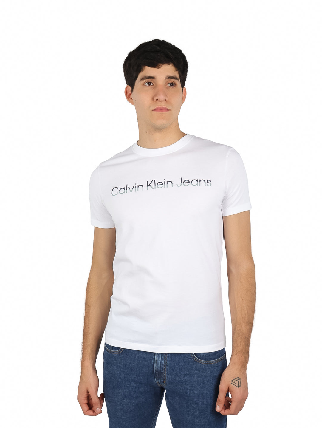 Hombre vistiendo playera blanca de cuello redondo con logotipo de Calvin Klein Jeans en el pecho.