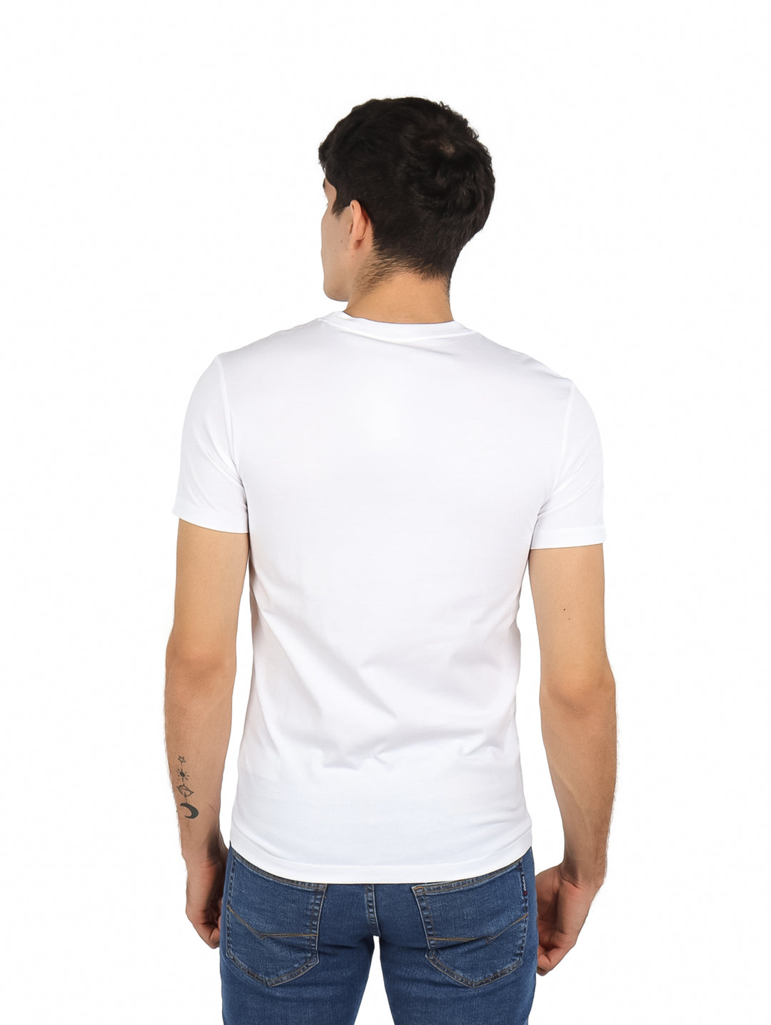 Hombre vistiendo playera blanca de cuello redondo con logotipo de Calvin Klein Jeans en el pecho.