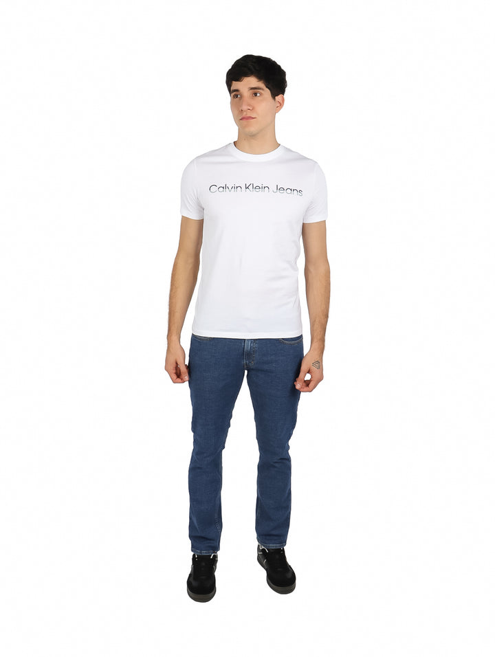 Hombre vistiendo playera blanca de cuello redondo con logotipo de Calvin Klein Jeans en el pecho.