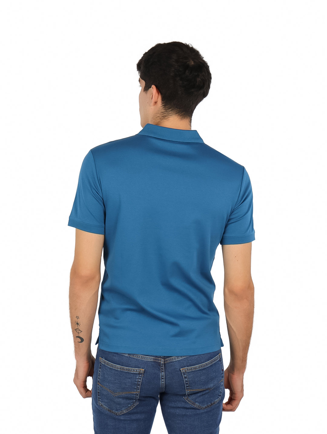 Hombre vistiendo una playera polo azul de manga corta de la marca Calvin Klein.