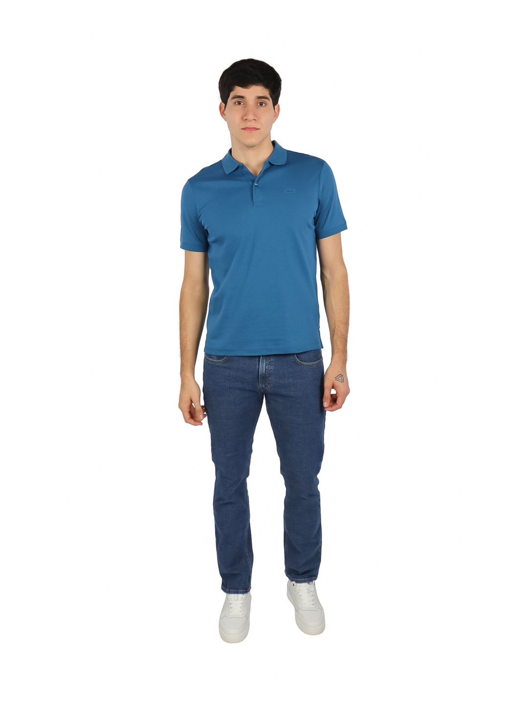 Hombre vistiendo una playera polo azul de manga corta de la marca Calvin Klein.