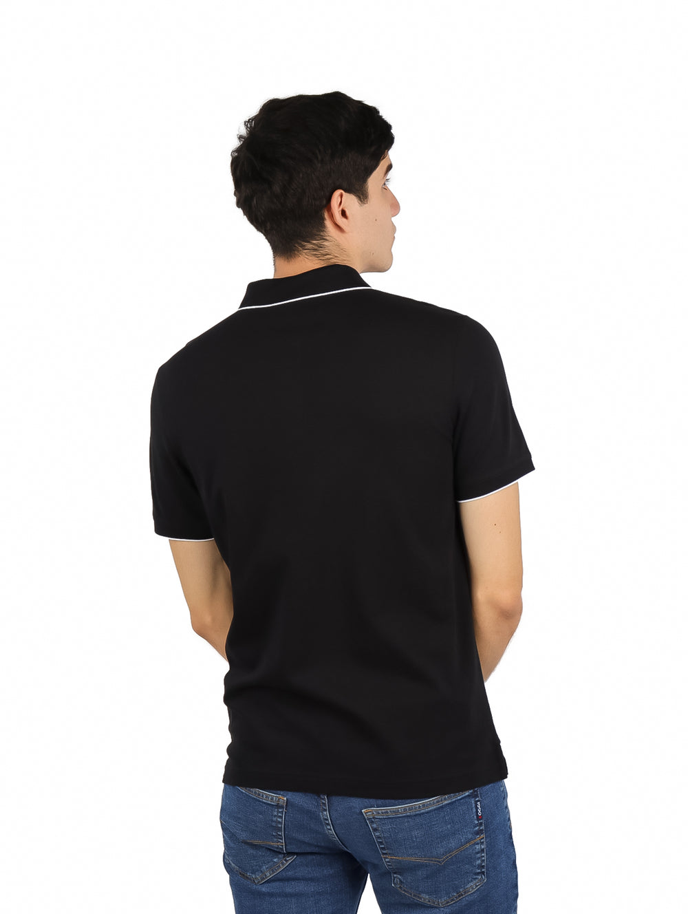 Hombre vistiendo polo negro de Calvin Klein con detalles blancos en cuello y mangas.