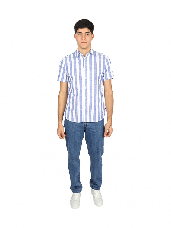 Hombre vistiendo camisa de manga corta con rayas verticales azules y blancas, estilo casual.