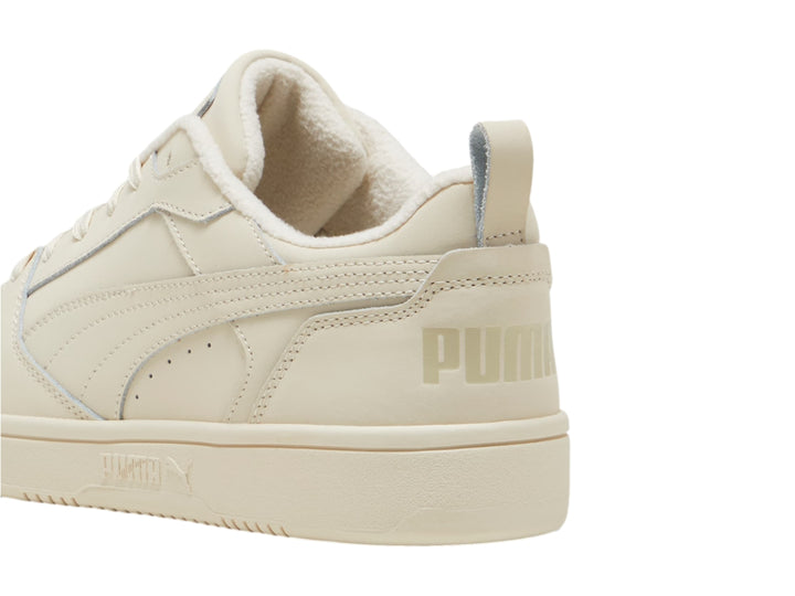 Tenis PUMA Rebound V6 Low de color blanco hueso con acabado en nubuck y corte bajo.