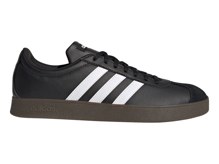Tenis Adidas color negro con tres franjas blancas laterales y suela marrón oscuro.