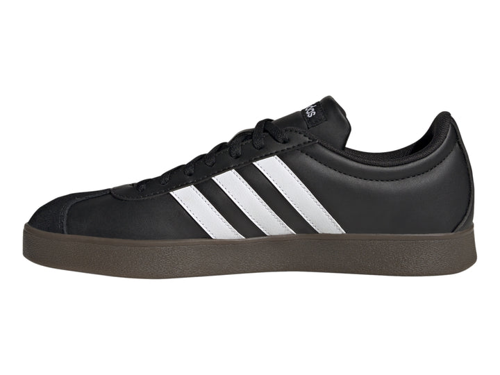 Tenis Adidas color negro con tres franjas blancas laterales y suela marrón oscuro.