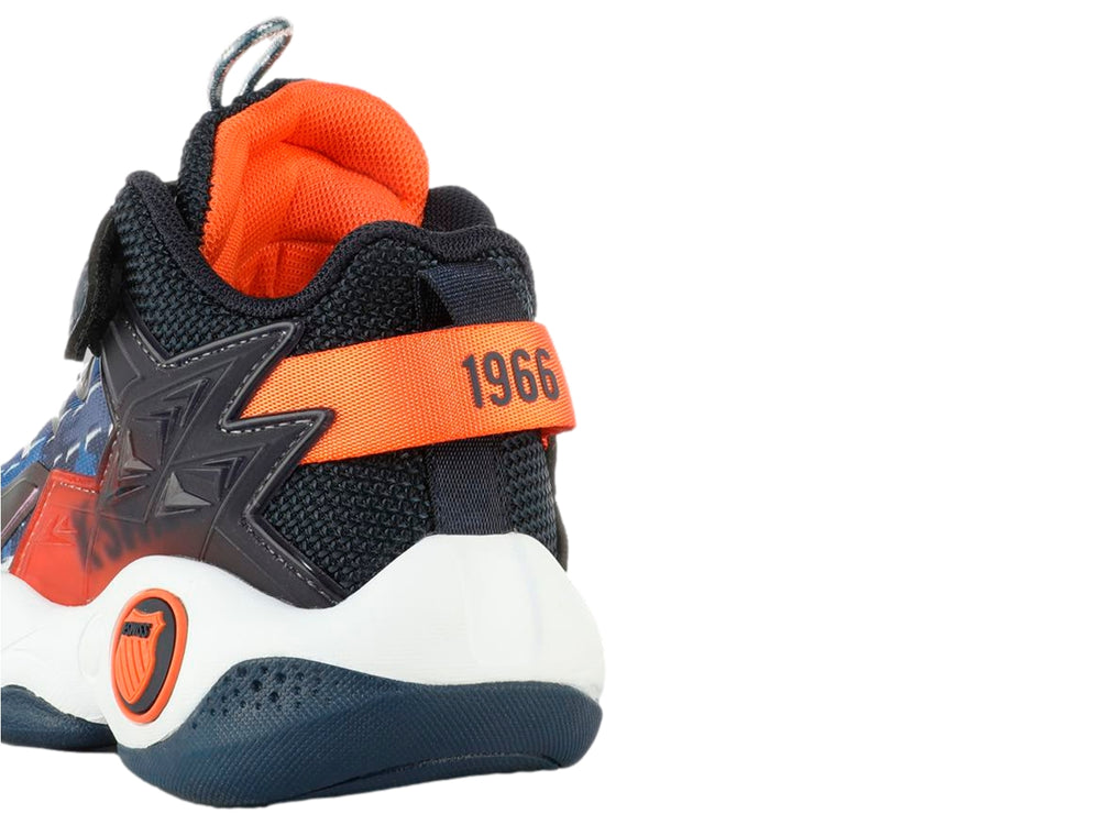 Tenis K-SWISS para niño en colores azul marino y naranja con suela blanca y cierre de correa velcro.