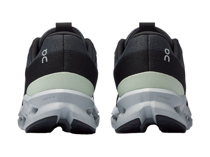 Tenis deportivos On Cloud color gris oscuro con suela gris claro y detalles en verde menta.