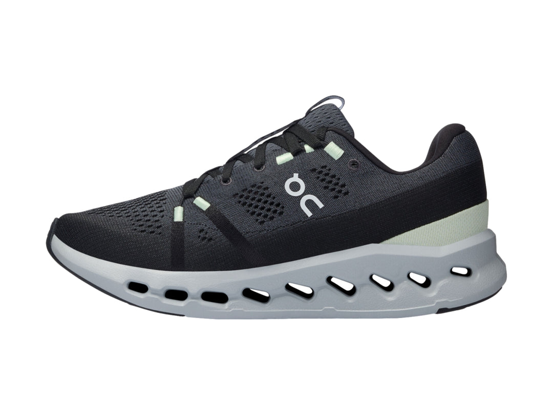 Tenis deportivos On Cloud color gris oscuro con suela gris claro y detalles en verde menta.