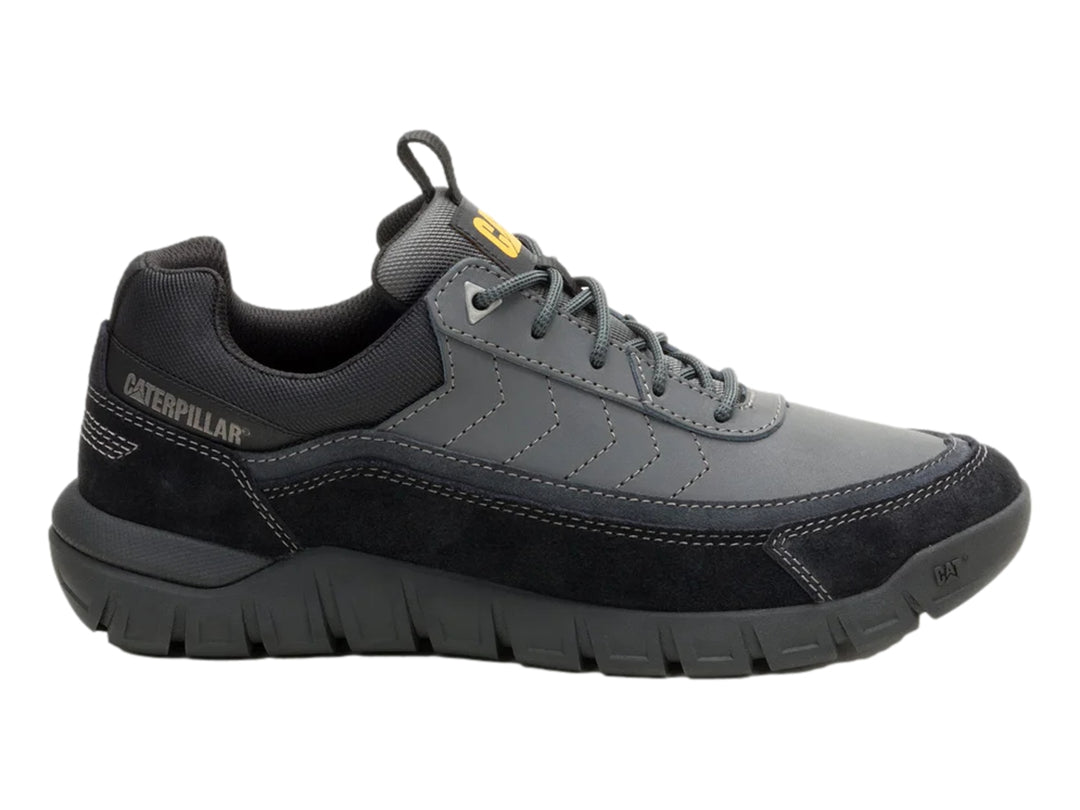 Tenis Caterpillar color gris oscuro con detalles en gamuza y suela gruesa.