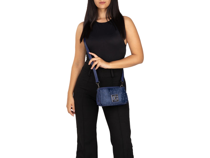 Bolso bandolera pequeño de color azul con logotipo metálico frontal y correa ajustable.