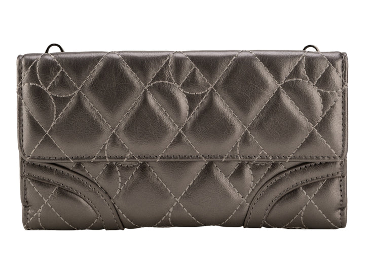 Bolso de mano Cloe color plata con acabado brillante, diseño acolchado y asa larga.