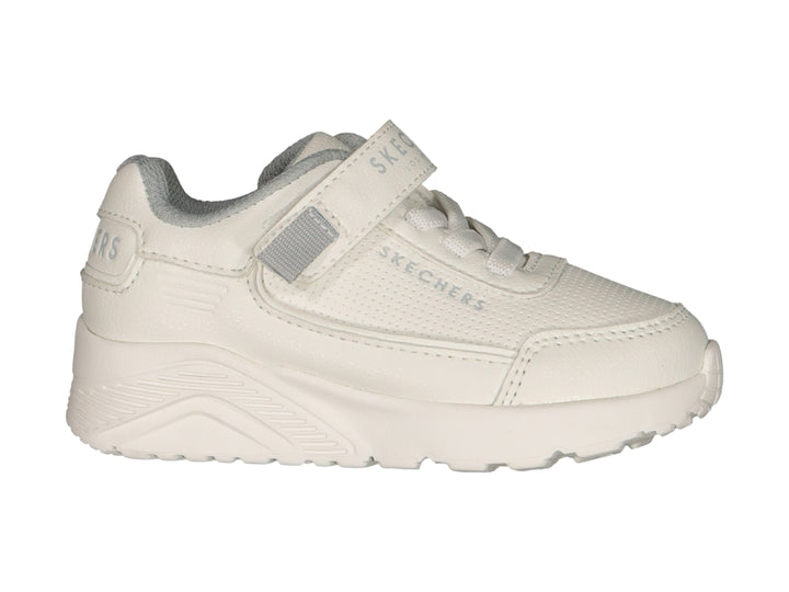 Tenis blancos Skechers con cierre de velcro y agujetas sobre fondo blanco.