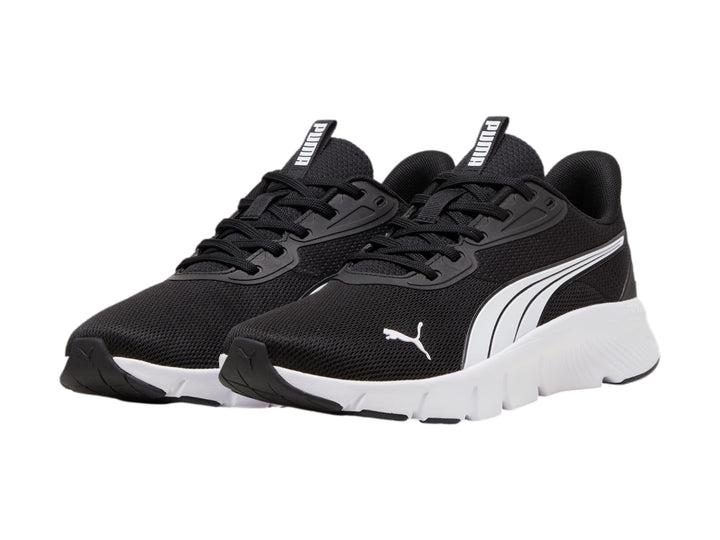 Tenis deportivos PUMA de color negro con suela blanca y franja lateral blanca.
