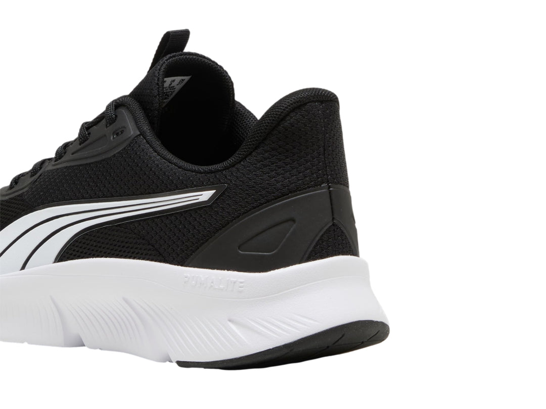 Tenis deportivos PUMA de color negro con suela blanca y franja lateral blanca.