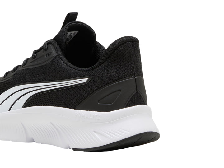 Tenis deportivos PUMA de color negro con suela blanca y franja lateral blanca.