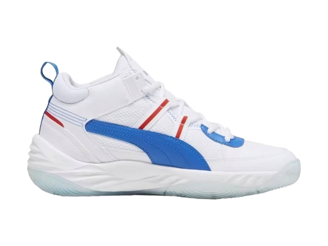 Tenis de baloncesto PUMA color blanco con franja azul y detalles rojos.