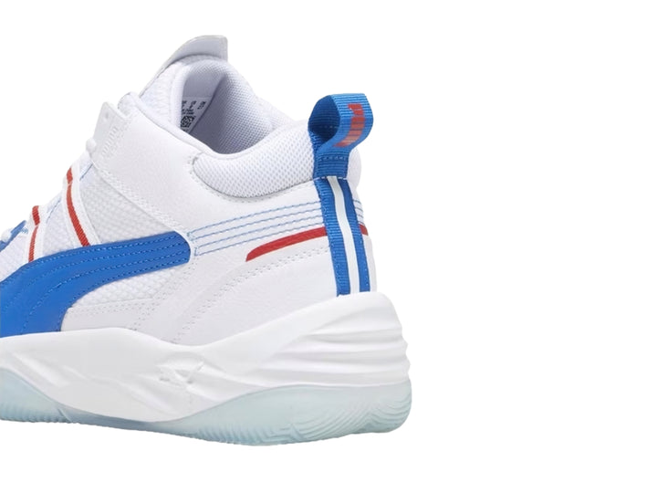 Tenis de baloncesto PUMA color blanco con franja azul y detalles rojos.