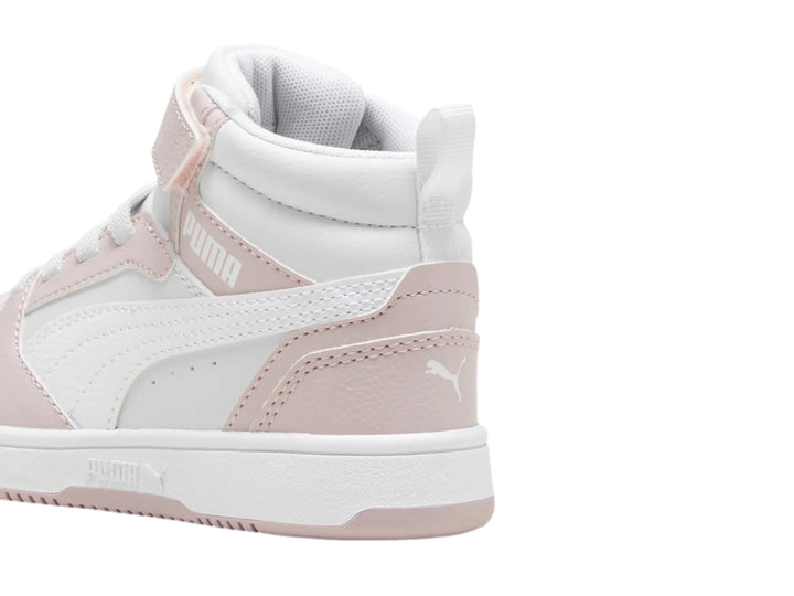 Tenis PUMA Rebound V6 Mid para niños en colores blanco y malva con cierre de velcro y agujetas.