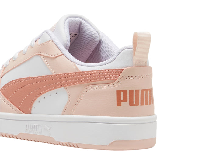 Tenis PUMA Rebound V6 Lo JR en colores blanco y rosa con suela blanca y detalles perforados.