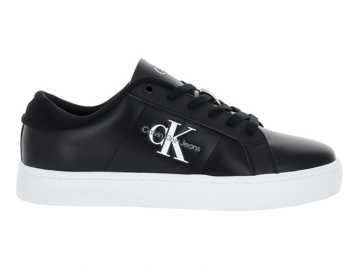 Tenis Calvin Klein de cuero negro con suela blanca y logotipo CK en el lateral.