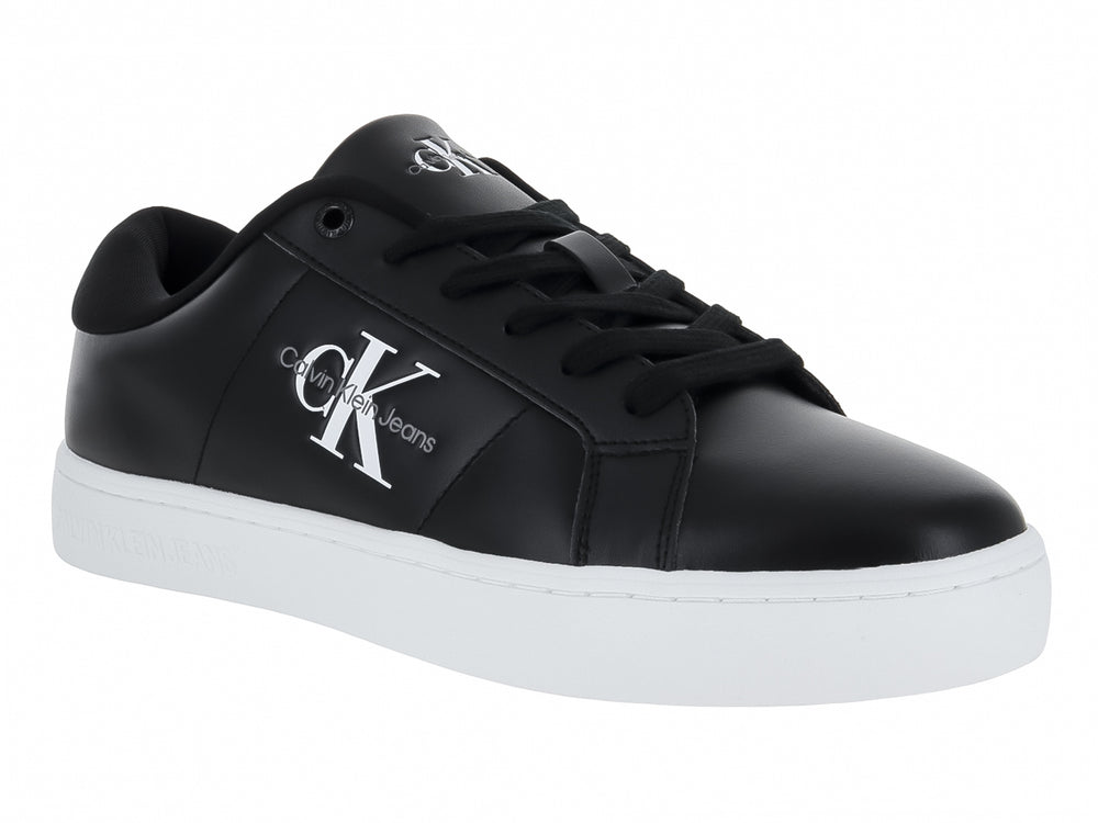 Tenis Calvin Klein de cuero negro con suela blanca y logotipo CK en el lateral.