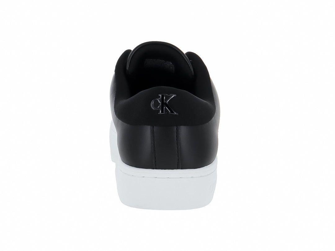 Tenis Calvin Klein de cuero negro con suela blanca y logotipo CK en el lateral.