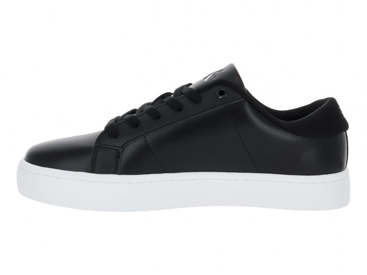 Tenis Calvin Klein de cuero negro con suela blanca y logotipo CK en el lateral.