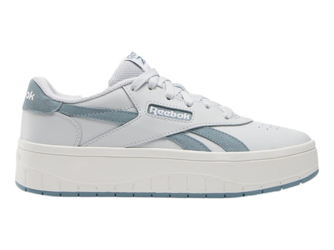 Tenis blancos Reebok con detalles en azul claro y suela de plataforma blanca.