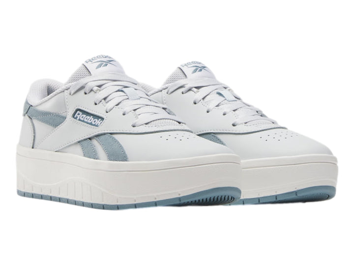 Tenis blancos Reebok con detalles en azul claro y suela de plataforma blanca.