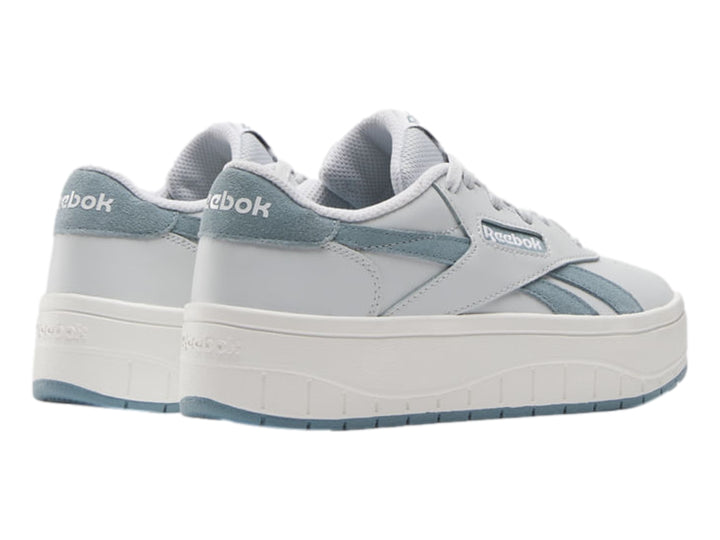 Tenis blancos Reebok con detalles en azul claro y suela de plataforma blanca.