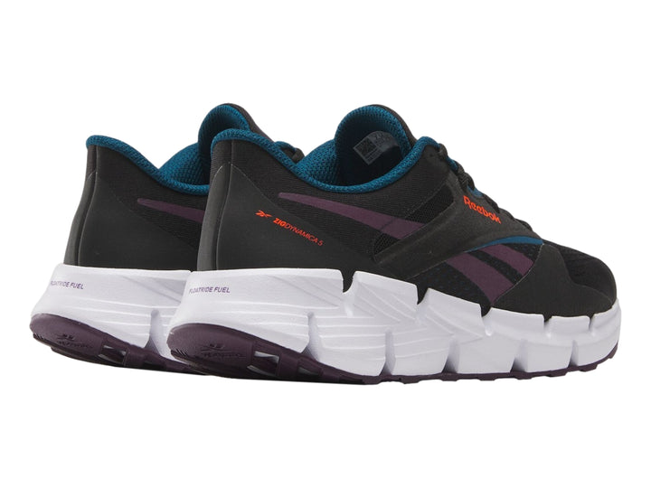 Tenis deportivos Reebok Zig Dynamica color negro con suela blanca y detalles en morado.