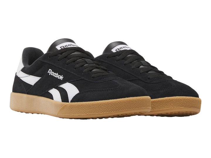 Tenis Reebok Smash Edge color negro con detalles blancos y suela de goma marrón.