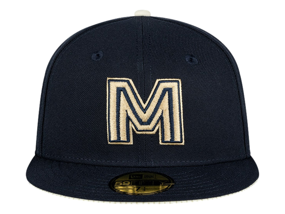 Gorra New Era color navy con letra M bordada en dorado y visera plana.