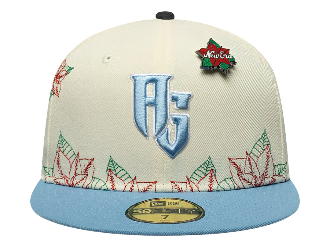 Gorra New Era blanca con visera azul claro y bordados navideños de flores rojas y verdes.